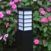 Lampa zewnętrzna Meriva w ogrodzie - kwiaty w tle